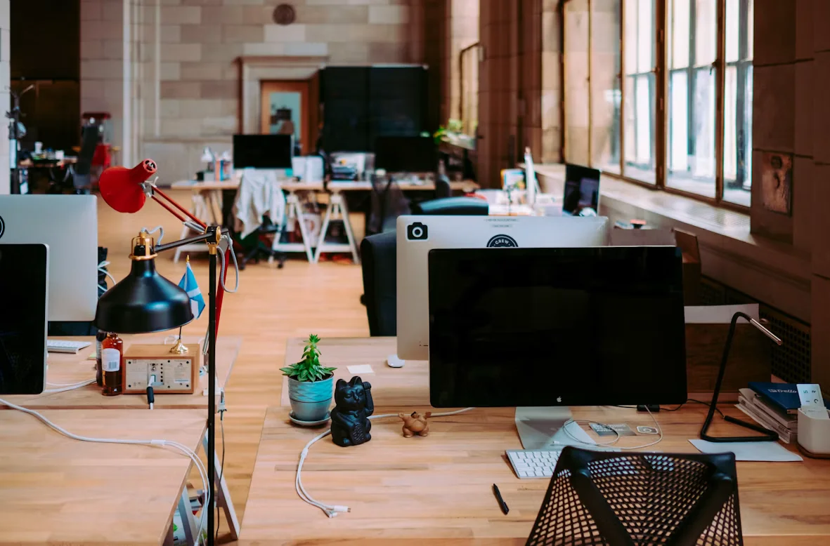 Un espace de travail partagé présente plusieurs postes informatiques sans personne.